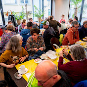 Alle sitzen zum Brunch an Tischen.