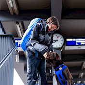 Vertrauenshund begleitet seine Halterin auf dem Bahnhof.