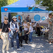 Besuchende beim Stand bei schönstem Wetter